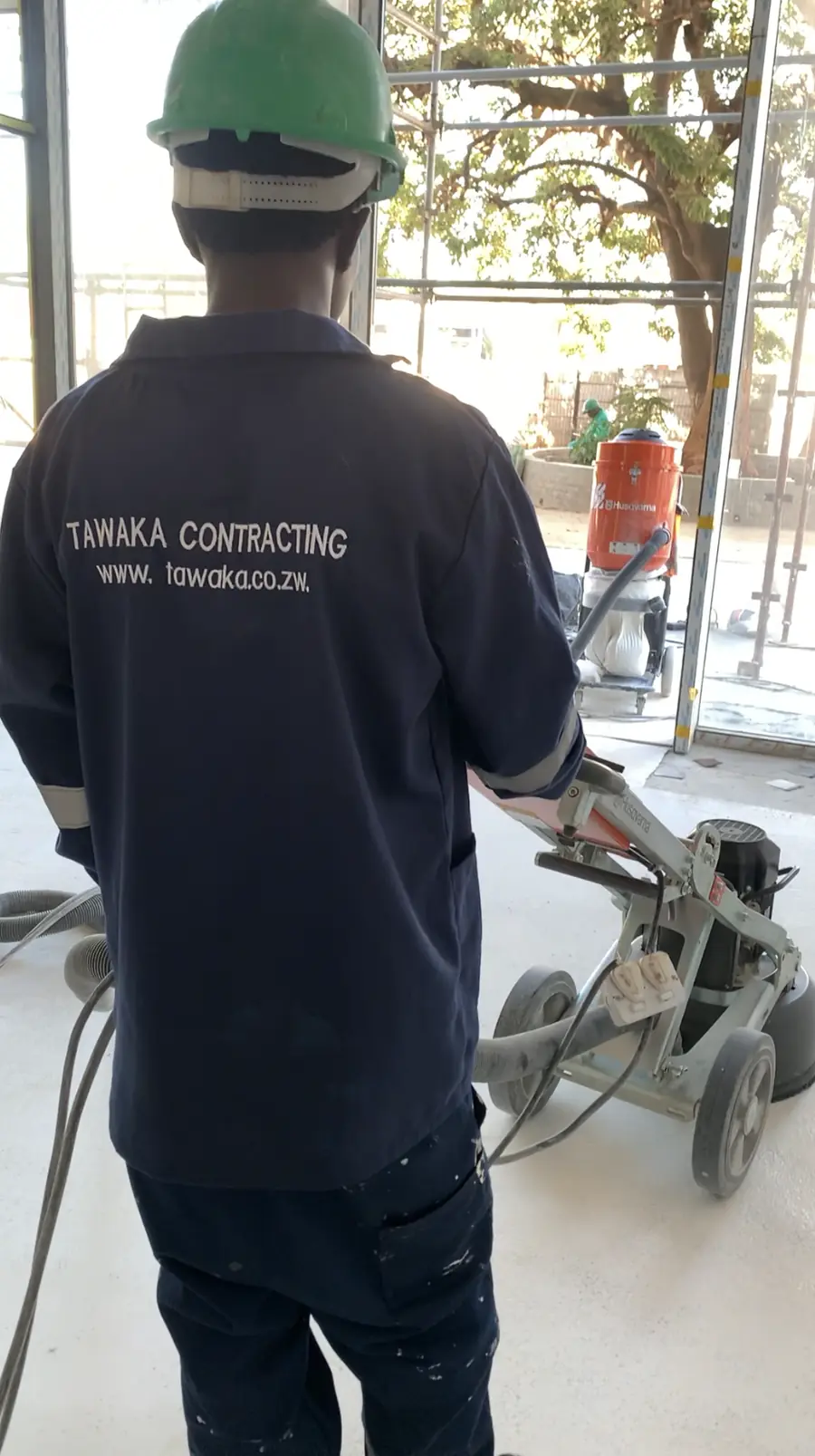 Floor preparation Harare — Tawaka Contracting operative machine-grinding a floor with dust extraction